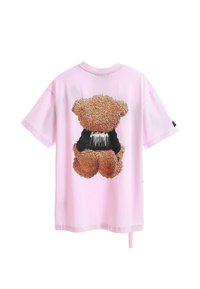 Camiseta de algodón rosa con un gráfico texturizado de un oso pardo en la parte posterior, elaborada con una tela suave, de corte relajado y mangas cortas.