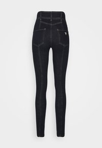 Jeans skinny de mezclilla negra con una cintura alta, que cuentan con cinco bolsillos y costuras en contraste. Diseño limpio y silueta ajustada.