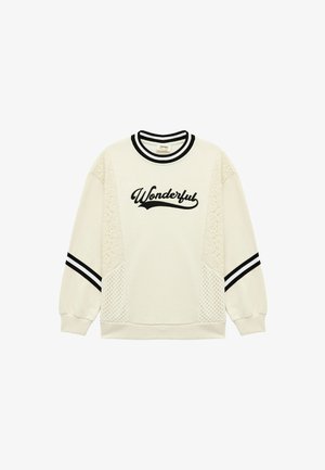 Creme sweatshirt med sort "Wonderful" broderi, blonde sidepaneler og sort-hvide stribede ærmer og halsudskæring. Blød tekstur.