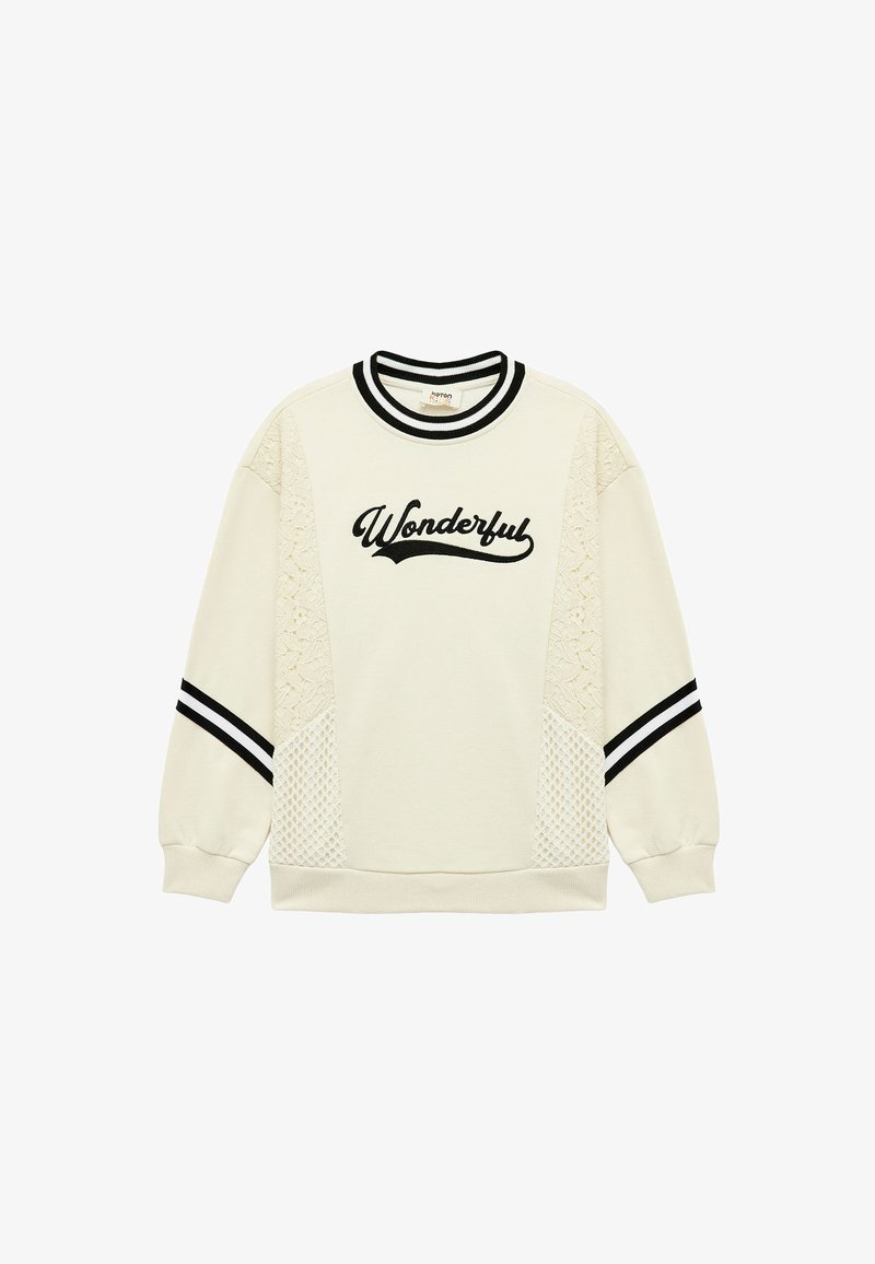 Felpa crema con ricamo nero "Wonderful", pannelli laterali in pizzo e polsini e colletto a righe bianco e nero. Texture morbida.