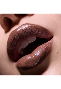 Brązowe usta z błyszczącym wykończeniem, prezentujące gradient od ciemniejszych do jaśniejszych odcieni, podkreślające teksturę i kształt. Obecny błyszczący połysk.