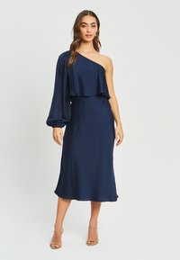 Navy blue satin dress featuring an asymmetrical design, one puff sleeve, and a flowing midi silhouette with a lightweight texture.