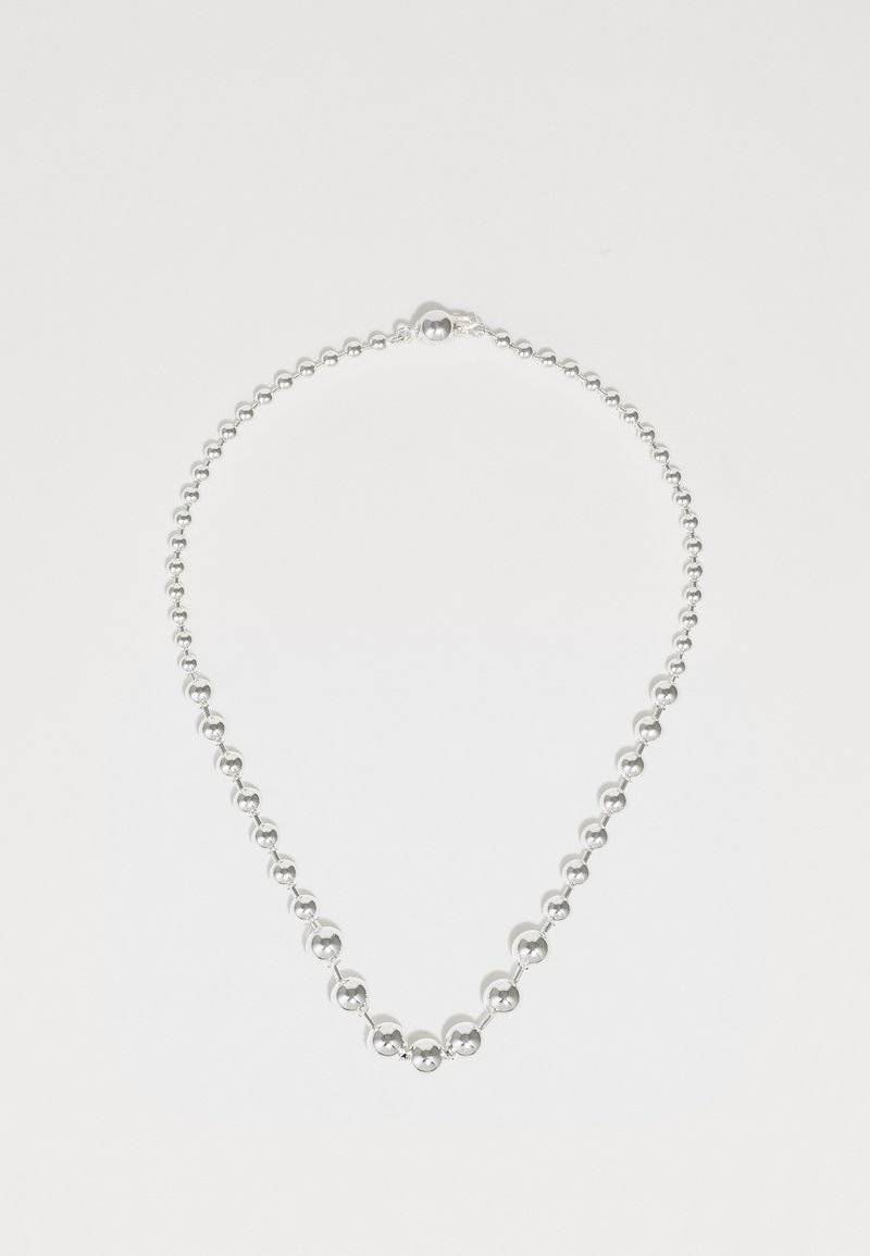 Sudraba kaklarota ar sēriju gludām, apaļām pērļu. Katra pērle maina izmēru, radot struktūras efektu pa ķēdi.