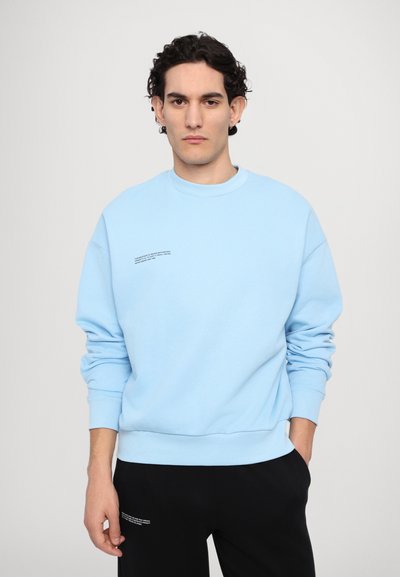 Lyseblå sweatshirt lavet af bomuldsblanding, med rund halsudskæring og ribbede ærmer. Inkluderer sort tekstdetalje på fronten.