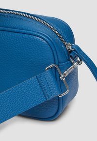 Blaues Leder-Crossbody-Tasche mit strukturierter Oberfläche, silbernem Reißverschluss und verstellbarem Gurt. Verfügt über eine abgerundete Form mit Ziernähten.