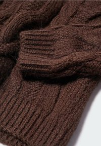 Pull en maille marron avec un motif torsadé texturé et des poignets côtelés, fabriqué dans un tissu doux mélange de laine, offrant un aspect décontracté et confortable.