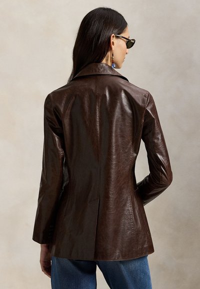 Καφέ δερμάτινο σακάκι με εφαρμοστή γραμμή, γιακά με χαραγή και άνοιγμα στο πίσω μέρος. Διαθέτει λεία υφή και κομψή σιλουέτα.