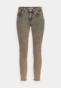 Jeans ajustados en denim azul desgastado con un acabado descolorido. Cuenta con cinco bolsillos, cierre de botón y dobladillos deshilachados para un look casual.