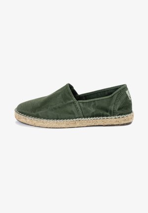 Espadrilles de tela verde con punta redondeada, costados elásticos y suela de yute trenzado, con un detalle de costura en contraste.