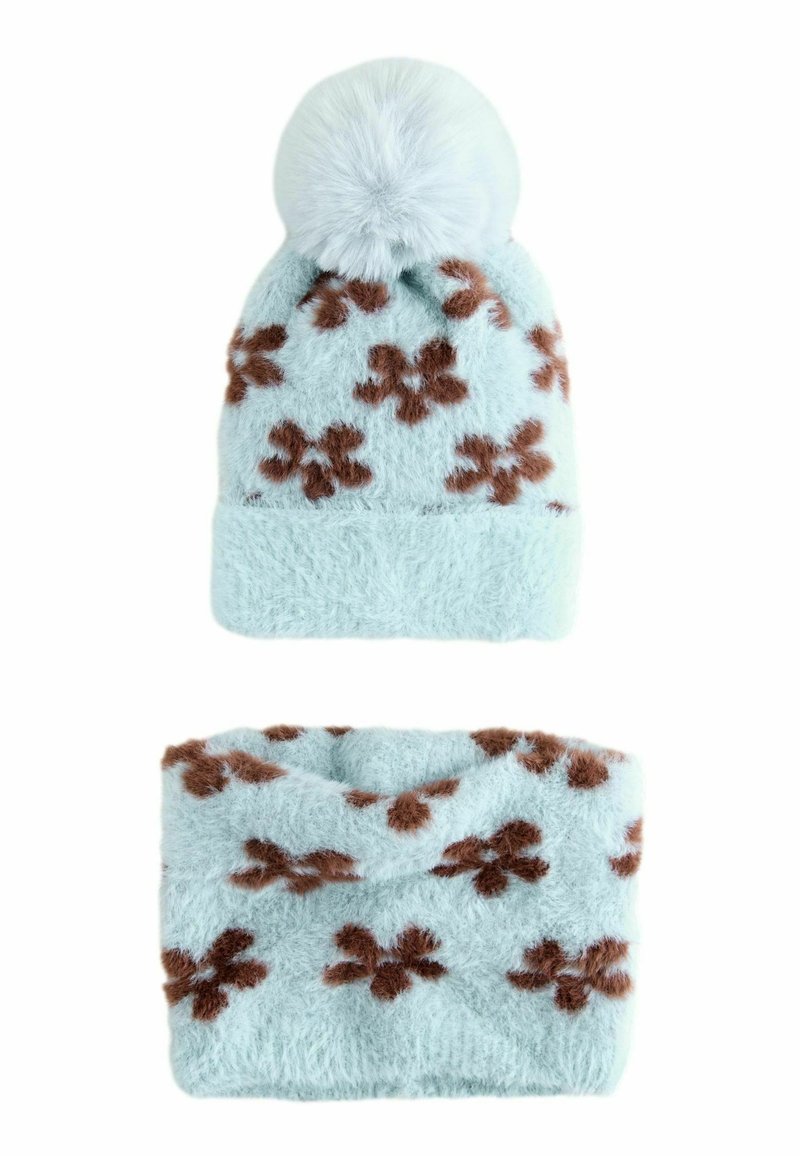 Gorro de punto esponjoso en azul claro con pompón y patrones florales marrones. Incluye un calentador de cuello a juego con el mismo diseño.