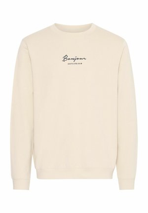 Kreminės spalvos džemperis ilgomis rankovėmis, su apvalia iškirpte ir tamsiai mėlynu spaudiniu „Bonjour Côté d'Azur“.