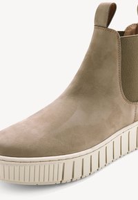 Bottine Chelsea en suède beige avec panneaux élastiques sur les côtés et semelle en caoutchouc blanche. Bout arrondi et détails de couture minimalistes.