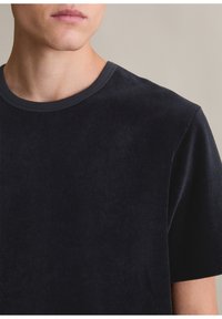Granatowa koszulka z sztruksu z okrągłym dekoltem i krótkimi rękawami, cechująca się miękką teksturą i delikatnym prążkowanym wzorem.