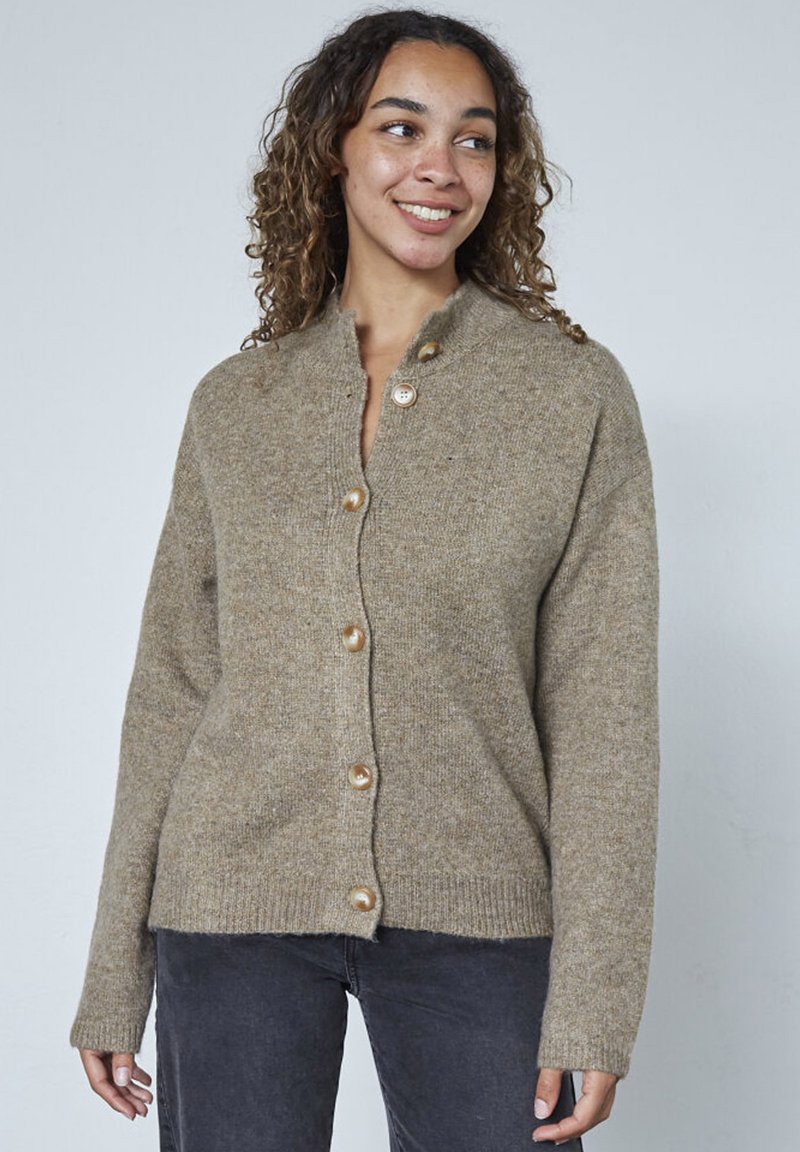 Beige knapkort cardigan lavet af tekstureret strikmateriale, med højt krave og fem runde knapper ned foran.