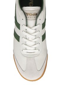 Sneaker bianco con strisce verdi, tomaia in pelle testurizzata, lacci bianchi, punta in suede grigia e suola in gomma marrone. Marchio Gola visibile.