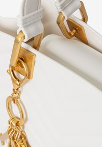 Weißer Handbeutel mit goldfarbenen Beschlägen, einer glatten Textur und einer strukturierten Form. Inklusive dekorativem Ketten- und Verschlussdetail.