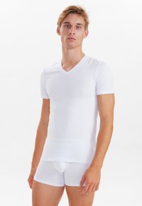 White short-sleeve V-neck t-shirt made from smooth fabric, paired with snug white boxer briefs, both featuring a clean, minimalist design.