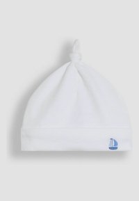 Weißer Baumwollbabyhut mit einem Knoten oben, ausgestattet mit einer hellblauen Segelboot-Stickerei am umgeschlagenen Rand. Weiche, glatte Textur.