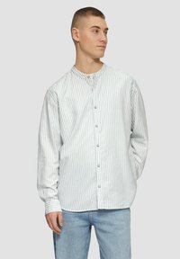 Gestreepte overhemden in lichtblauw en wit, katoen stof, ronde kraag, lange mouwen met knoopmanchetten, relaxte pasvorm, enkele knoopsluiting.