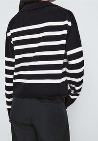 Pull en tricot rayé bleu marine et blanc avec col, présentant un col et des poignets côtelés, une coupe crop et une texture lisse.