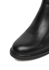 Czarne skórzane botki do kostki z okrągłym noskiem, gładką teksturą i subtelnym przeszyciem wzdłuż podeszwy dla zwiększonej wytrzymałości.