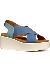 Sandalo wedge in pelle blu con design a cinturini incrociati, soletta color cammello e suola piatta bianca. Dettagli texturizzati sul tallone e sui lati.