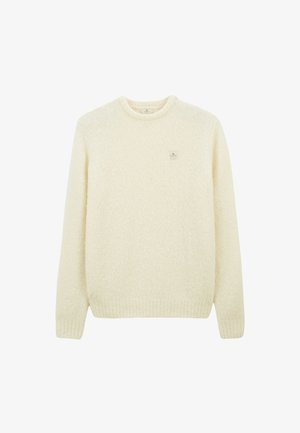 Pull en laine texturé de couleur crème avec des manches longues, des poignets et un ourlet côtelés, et un petit patch logo carré sur la poitrine gauche.