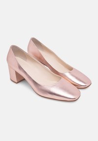 Rose gold metallic heels with a square toe and a block heel. Smooth texture with a low-cut silhouette and soft, beige insoles.