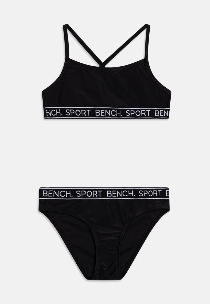 Zwart sportondergoedset, met een cropped top en gekruiste banden en bijpassende slipjes, beiden met witte merk-elastieken.