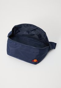 Borsa in nylon blu navy con chiusura a zip, dotata di un compartimento interno. Logo ricamato in rosso, arancione e giallo su un lato.