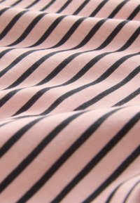 Lys pink stof med sorte diagonale striber, blød tekstur og en glat overflade, der viser mønsterets gentagelse og bevægelse.