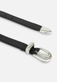 Cintura in pelle nera con texture liscia, fibbia in metallo argentato inclinata e punta appuntita. Diversi fori di regolazione lungo la cintura.