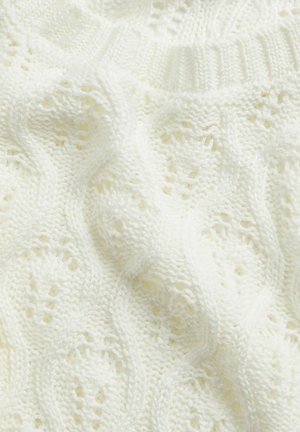 Knitted sweater in soft white yarn, featuring a textured pattern with wavy lines and small openwork details throughout the fabric.