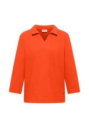 Haut texturé à manches longues de couleur orange vif avec un col et un décolleté en V, mettant en avant une petite étiquette de marque à l'intérieur du col.