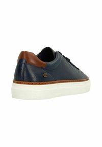 Marineblauwe leren sneaker met bruine hielaccent, witte rubberen zool en zwarte veters, getoond vanuit een achterste zijaanzicht.