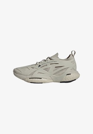 Light gray athletic sneakers with mesh and synthetic materials, textured sole, prominent branding, and a rounded shape.