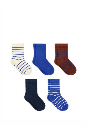 Cinq paires de chaussettes pliées crème avec des rayures bleues, bleu uni, marron avec des rayures bleues, bleu marine uni et bleu avec des rayures blanches sur fond blanc.