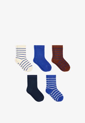 Cinq paires de chaussettes pliées crème avec des rayures bleues, bleu uni, marron avec des rayures bleues, bleu marine uni et bleu avec des rayures blanches sur fond blanc.