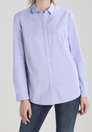 Lichtblauw overhemd met lange mouwen gemaakt van een gestructureerde stof, met een knoopsluiting aan de voorkant en een klassieke kraag, gecombineerd met donkere jeans.