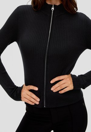 Pull noir côtelé à fermeture éclair avec col montant et manches ajustées, doté d'une fermeture éclair argentée et d'une silhouette élancée.