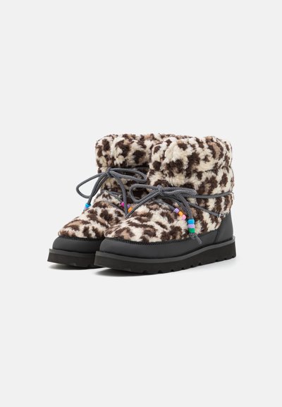 Round-toed, mid-calf boots made of fuzzy brown-and-cream patterned material, featuring black rubber soles and colorful beaded accents on laces.