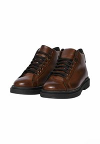 Scarpe in pelle marrone con lacci neri, punta arrotondata e colletto imbottito. Presentano una superficie testurizzata e una suola in gomma nera.