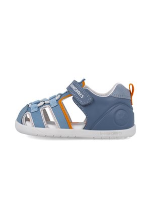 Sandalias sintéticas azules con diseño de punta cerrada, tira de Velcro, acentos naranjas en contraste y lados con cortes para ventilación.