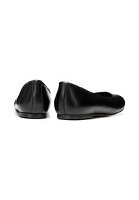 Bailarinas de piel negra con punta redondeada, diseño minimalista, textura suave y suela de goma de perfil bajo. Vista desde atrás.