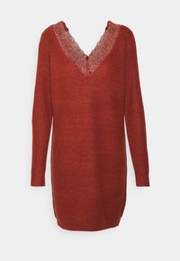 Robe pull en tricot rouge profond avec de longues manches et un décolleté en V à motifs ondulés. Tissu texturé, design jusqu'aux genoux.