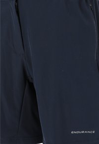 Marina shorts i lättviktsmaterial, med en texturerad innervåning, sidofickor med dragkedja och "ENDURANCE"-logotyp på fållen.