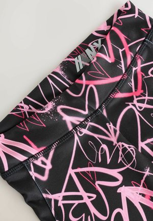 Leggings negre cu un model abstract de inimi roz, având un logo în colțul din stânga sus și cusături contrastante pe margini.