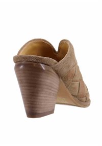 Mule con tacco in suede beige con design intrecciato, retro arrotondato e tacco a cono in legno di altezza media. Dettagli includono una fodera in pelle liscia.