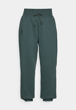 Mörkgröna joggers i mjukt tyg med elastisk midja och dragsko, ankle cuffs och en liten logodetalj på sidan.
