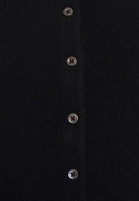 Cardigan nero in maglia con sei bottoni rotondi in argento sul davanti, realizzato in un tessuto testurizzato e con un design classico senza chiusura.